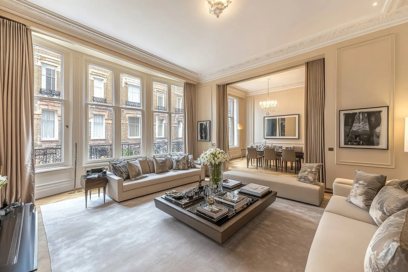 A light, classically detailed living and dining room with tall sash windows and bespoke joinery.